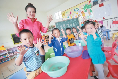 10月15日,在东港区营子幼儿园,老师在教小朋友们正确的洗手方法.